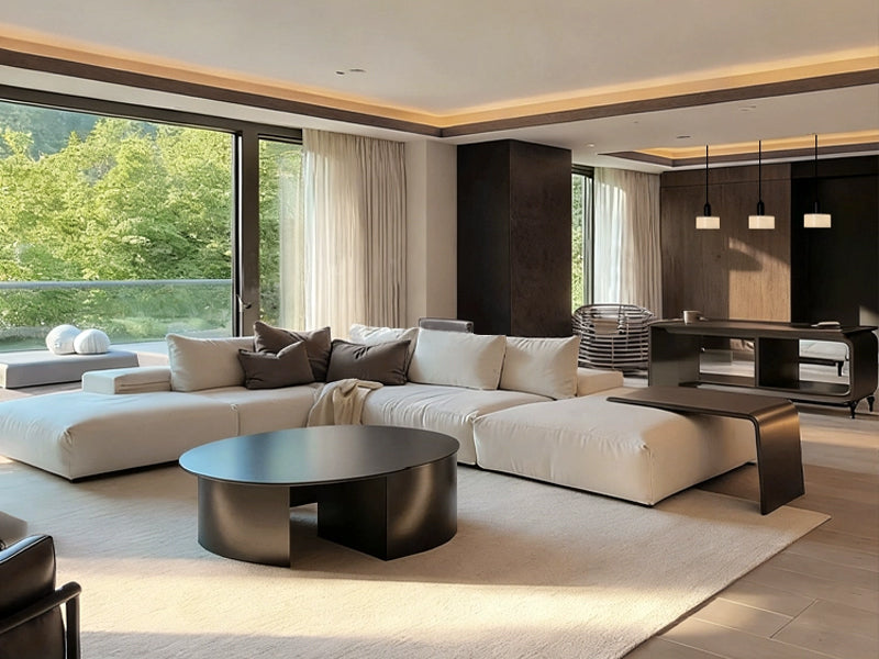 In a modern light luxury living room with dark gray walls, an irregular light coffee sofa is paired with a single chair, and floor-to-ceiling windows bring in greenery, creating an elegant and tranquil atmosphere.