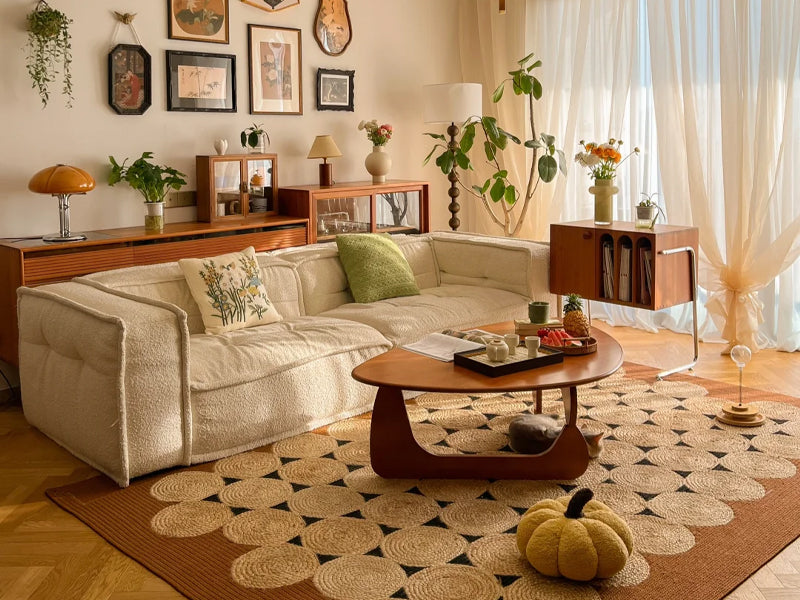 In a sunlit wabi-sabi style dining room, there is a round dining table and chairs combining rattan and wood, wall-mounted shelves complement the green plants, and soft warm light creates a healing and relaxing atmosphere.