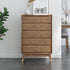 Wooden dresser with gold knobs in a room setting with plants and decor.