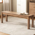 Wooden table with an open book on a textured rug in a room setting.