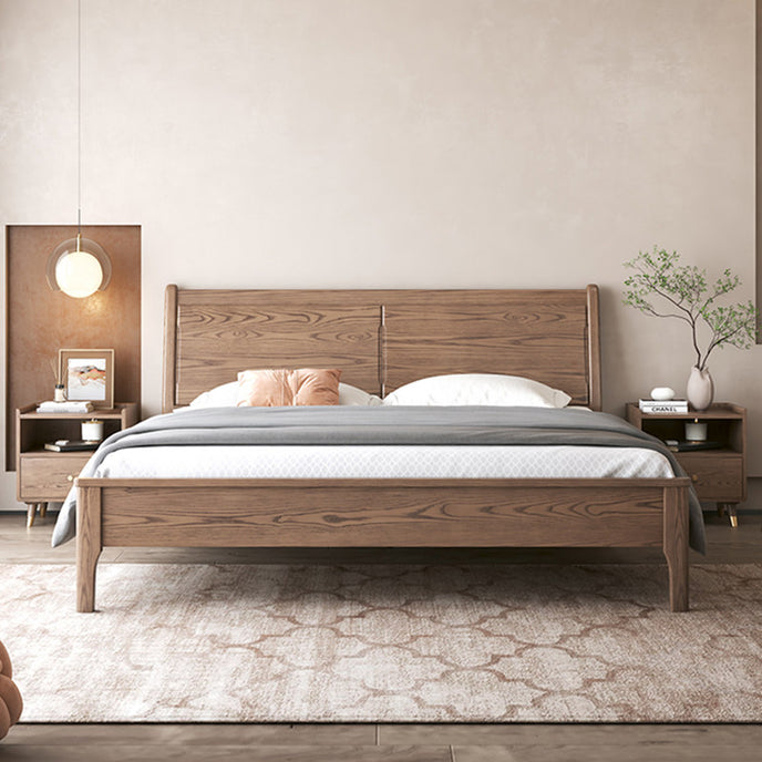 Wooden bed in a bedroom setting with side tables and decor.