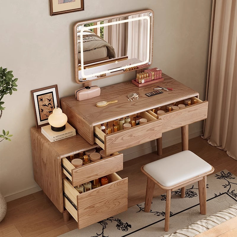 Wooden vanity table with illuminated mirror, drawers, and small stool