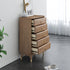 Wooden dresser with multiple drawers in a room with a plant and framed picture.