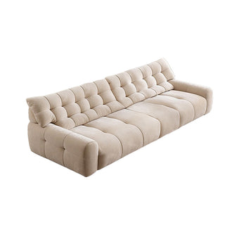 A light beige quilted fabric sofa with a plump, soft appearance.