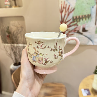 Handled teacup with rabbit illustration and cream spoon
