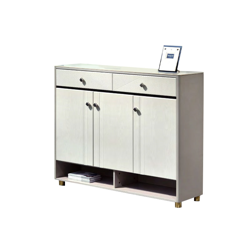 White sideboard with three doors and a drawer on a white background